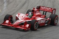 En röd Indianapolis-fordon kör längs banan. (AI text)