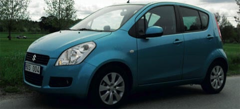 En blå Suzuki Saturn S-Max parkerad vid en vägkant. (AI text)