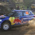 En rallybil kör ner längs en grusväg. (AI text)