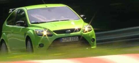 En grönglansad Ford Focus RST kör på en racerbana. (AI text)