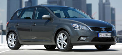 En grå bil parkerad framför en stad. (AI text)