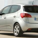 En silverfärgad bil står parkerad på en gata. (AI text)