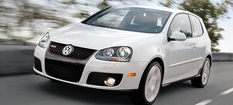 En vit Volkswagen Golf GTI kör nerför vägen. (AI text)