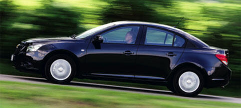 En svart bil kör nerför en väg. (AI text)