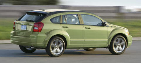 En grönt Dodge Caliber kör nedför vägen. (AI text)