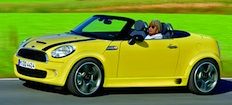En gul Mini Cooper cabriolet kör nerför en landsväg. (AI text)