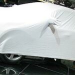 En bil täckt av vit duk (AI text)