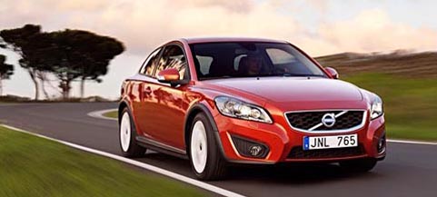 En röd Volvo C40 kör ner en väg. (AI text)