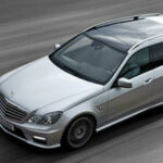 En Mercedes-Benz E-sedan kör på vägen. (AI text)