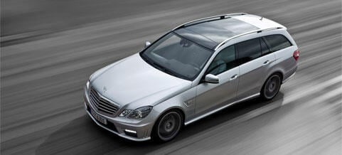 En Mercedes-Benz E-sedan kör på vägen. (AI text)
