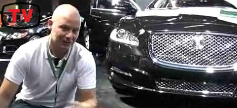 En man sitter på golvet bredvid en Jaguar XJ. (AI text)