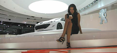 En kvinna sitter på en bil på bilsalongen. (AI text)