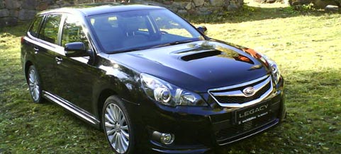 En svart Subaru WRX parkerad på en gräsmatta. (AI text)