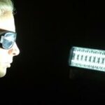 En kvinna i solglasögon tittar på en ljus källa. (AI text)