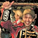 en race car-förare firar sin seger tillsammans med sitt team (AI text)