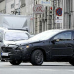 En man cyklar på en gata medan en bil står stilla bredvid honom. (AI text)