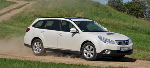 En vit Subaru Outback kör längs en grusväg. (AI text)