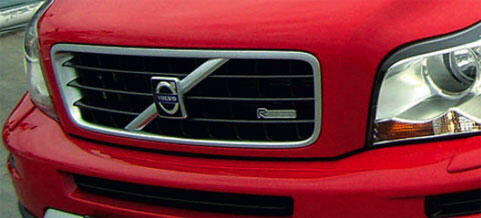 En röd Volvo NEO parkerad i en parkeringsplats. (AI text)