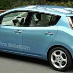 En Nissan Leaf elbil kör längs vägen. (AI text)