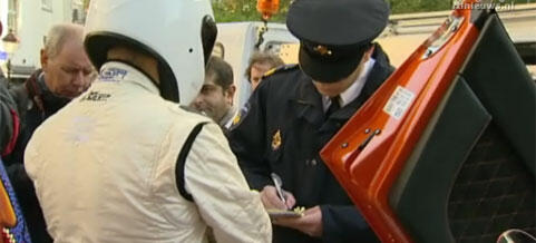 En polisväktare står bredvid en racerbil. (AI text)