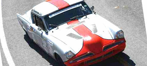 En klassisk bil kör nerför vägen. (AI text)