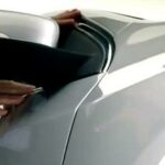 En affärsman öppnar dörren till en bil. (AI text)