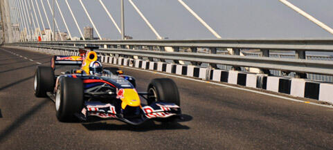 Red Bull-racingbil kör över en bro (AI text)