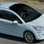 En blå Citroën C3 kör nedför en väg. (AI text)