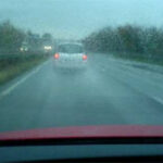 en bil kör nerför en regnig väg (AI text)