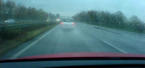 en bil kör nerför en regnig väg (AI text)