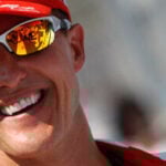 En man i en röd hatt och solglasögon leder vänligt. (AI text)