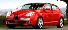 En röd Alfa Romeo kör längs en väg. (AI text)