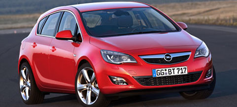 En Opel Astra - en röd bil kör på en väg. (AI text)
