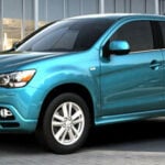 En blå SUV parkerad framför ett byggnad. (AI text)