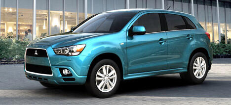 En blå SUV parkerad framför ett byggnad. (AI text)