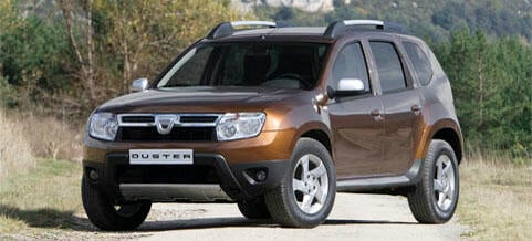 En brun SUV kör längs en grusväg. (AI text)