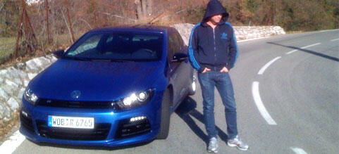 En man står bredvid en blå Volkswagen Golf R. (AI text)