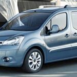 En blå Citroën Berlingo står parkerad framför ett hus. (AI text)