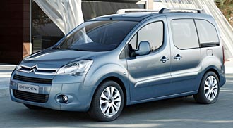 En blå Citroën Berlingo står parkerad framför ett hus. (AI text)