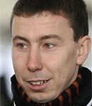 En man i svart jacka och orange scarf. (AI text)