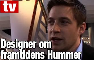 En man i kostym och slips pratar inför en kamera. (AI text)