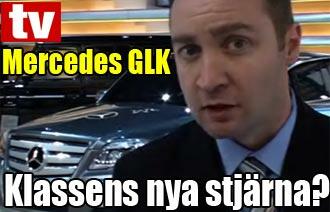 En man i kostym och slips pratar med en Mercedes GLK. (AI text)