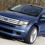 En blå Ford Edge kör längs en väg. (AI text)