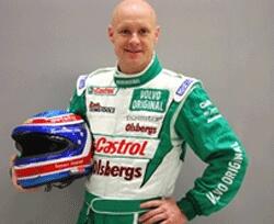 En man i ett grönt och vitt racingskjortel ställer sig för en foto. (AI text)