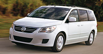 En vit Volkswagen cabriolet kör nerför en väg. (AI text)