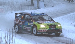 En rallybil kör genom snön. (AI text)