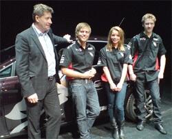 En grupp personer står bredvid en bil. (AI text)