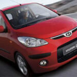 En röd bil kör nerför en väg. (AI text)