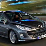 En bil körer nedför en stadsgata. (AI text)