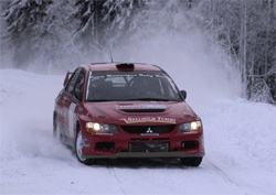 En röd rallybil kör genom snön. (AI text)